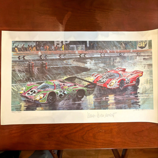 A vertical art print featuring two race cars on a racetrack, displayed on a wooden table. The top car is green and pink with the number 3, and the bottom car is red with the number 55.